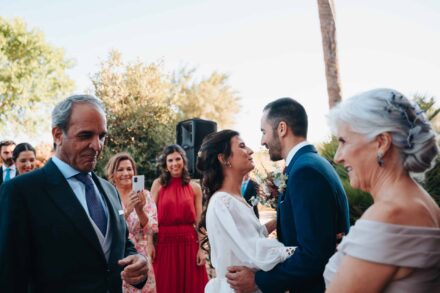 El novio abraza a la novia al llegar a la ceremonia, entre las sonrisas de los invitados