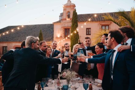 Los invitados brindan en pie en el banquete, ante la espadaña de Hacienda Los Molinillos (Sevilla)