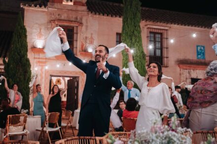 Los novios ondean servilletas y el novio alza el pulgar ante la fachada de Hacienda Los Molinillos (Sevilla)