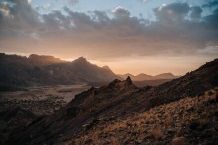 Atardecer entre nubes sobre las montañas y la llanura volcánica del parque nacional del Teide (Tenerife)