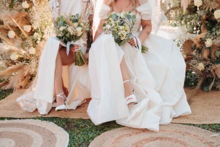 Ramos y sandalias blancas de las novias, sentadas con los pies sobre alfombras de esparto durante la ceremonia