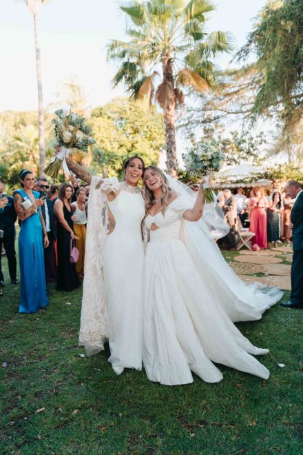 Lola Gallardo y Cristina levantan sus ramos abrazadas entre los invitados al terminar la ceremonia