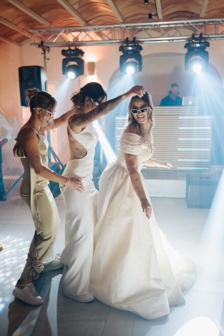 Andrea Medina baila con las novias en la pista, una de ellas con gafas de sol blancas