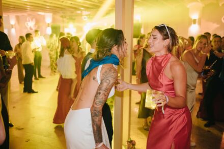 Alexia Putellas, con vestido rosa y un vaso en la mano, ríe junto a Lola Gallardo en la fiesta