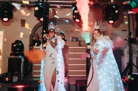 Las novias, con coronas y capas de luces, disparan cañones de humo entre confeti frente a la cabina del DJ