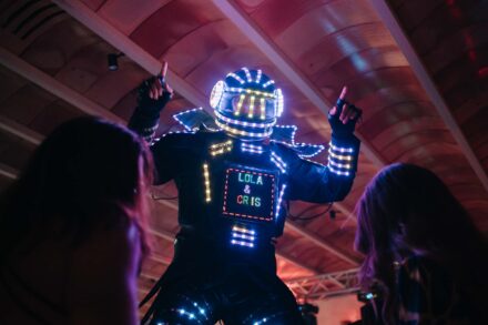 Un robot de luces LED baila sobre los invitados con «LOLA & CRIS» en la pantalla del pecho