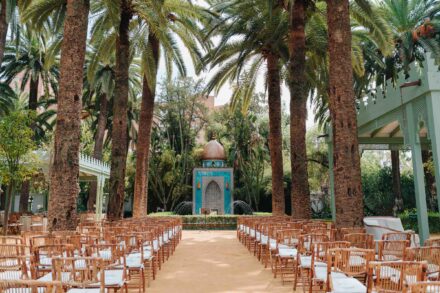 Outdoor wedding ceremony setup at Hacienda Villa Luisa with palm trees, aisle chairs and a decorative altar in Seville