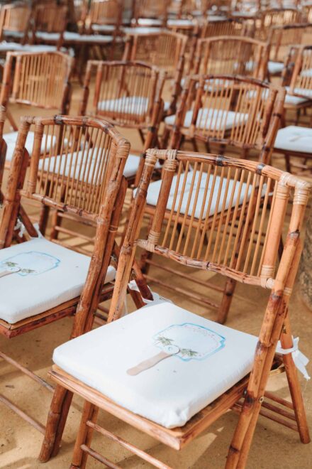 Wooden ceremony chairs with fans prepared for guests at Hacienda Villa Luisa wedding Seville