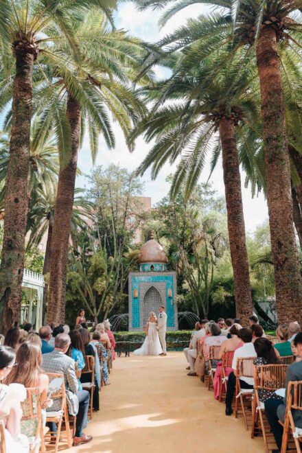 bride and groom standing in front of turquoise fountain during ceremony in seville