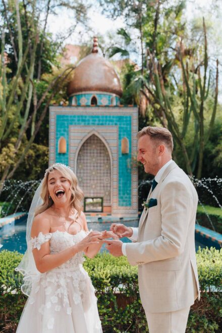 bride and groom standing in front of turquoise fountain during ceremony in seville