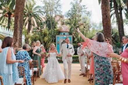 Salida de los novios tras la ceremonia civil en Hacienda Villa Luisa, rodeados de invitados lanzando pétalos en una boda en Sevilla