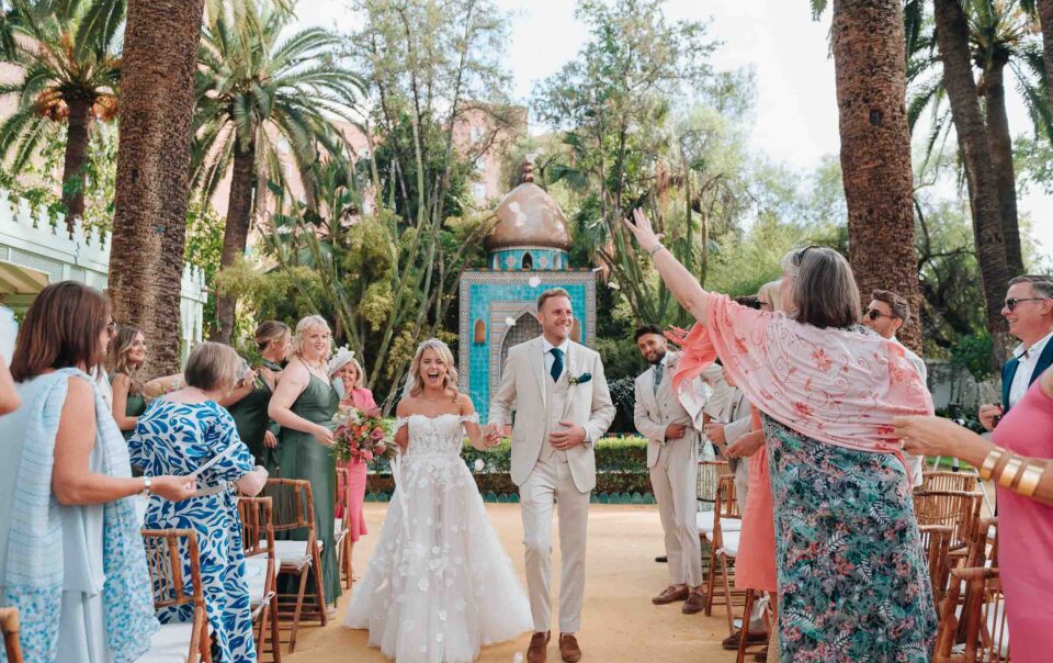 Salida de los novios tras la ceremonia civil en Hacienda Villa Luisa, rodeados de invitados lanzando pétalos en una boda en Sevilla
