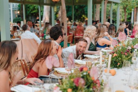 guests laughing around decorated table during outdoor wedding dinner in Seville