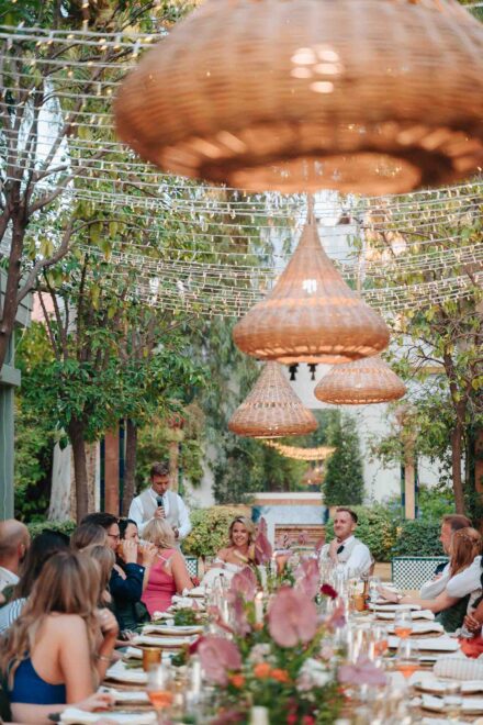 guests laughing around decorated table during outdoor wedding dinner in Seville