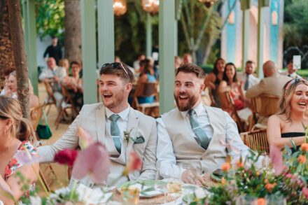 guests laughing around decorated table during outdoor wedding dinner in Seville