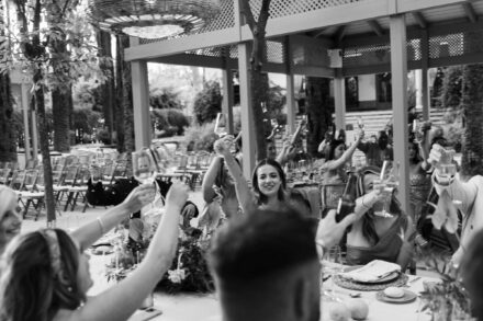 group of wedding guests smiling at camera seated at outdoor dinner table in Seville