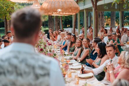 group of wedding guests smiling at camera seated at outdoor dinner table in Seville
