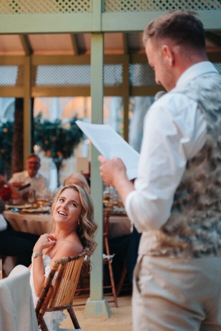group of wedding guests smiling at camera seated at outdoor dinner table in Seville