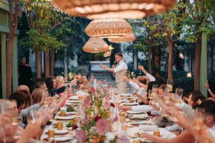 group of wedding guests smiling at camera seated at outdoor dinner table in Seville