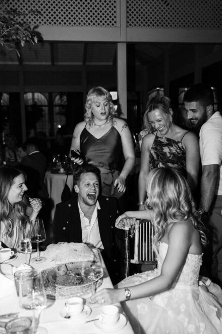 group of wedding guests smiling at camera seated at outdoor dinner table in Seville