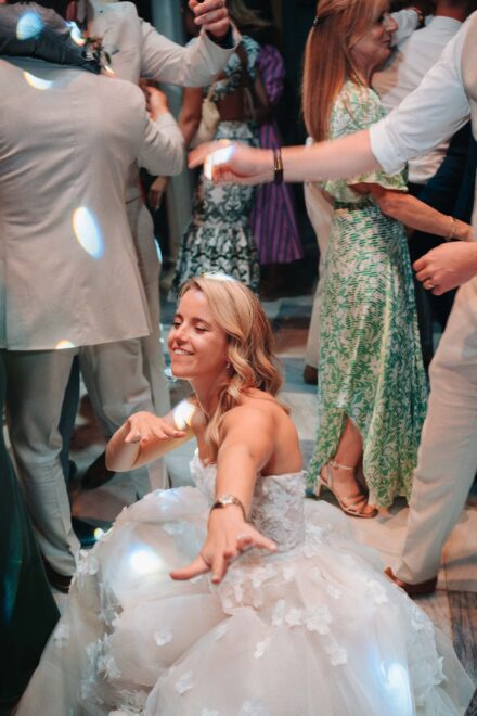 bride dancing on the floor surrounded by guests and party lights during wedding reception in Seville