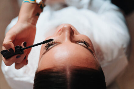 Bride having mascara applied during bridal makeup preparations before the wedding