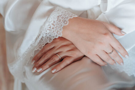 Close-up of the bride’s hands with engagement ring and wedding band during bridal preparations