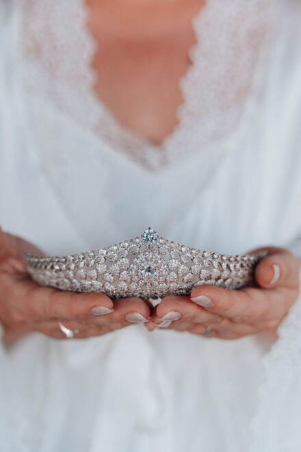 Bride holding a sparkling bridal tiara during wedding preparations