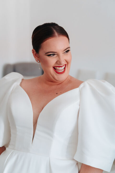 Smiling bride in a white wedding dress during bridal preparations