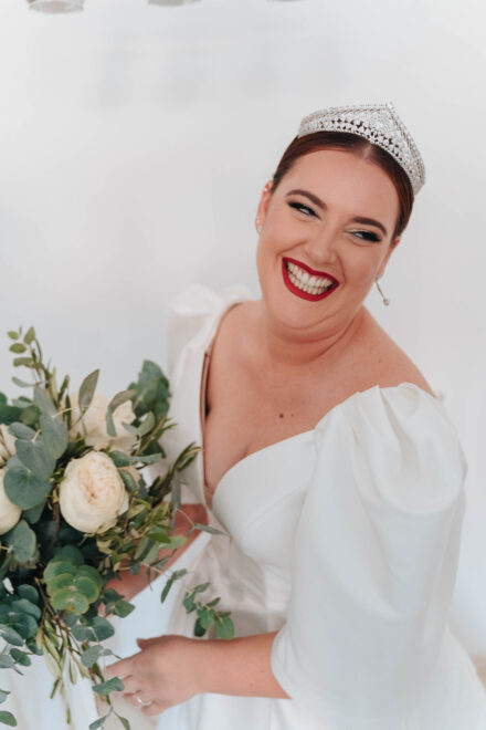 Smiling bride in a white wedding dress during bridal preparations