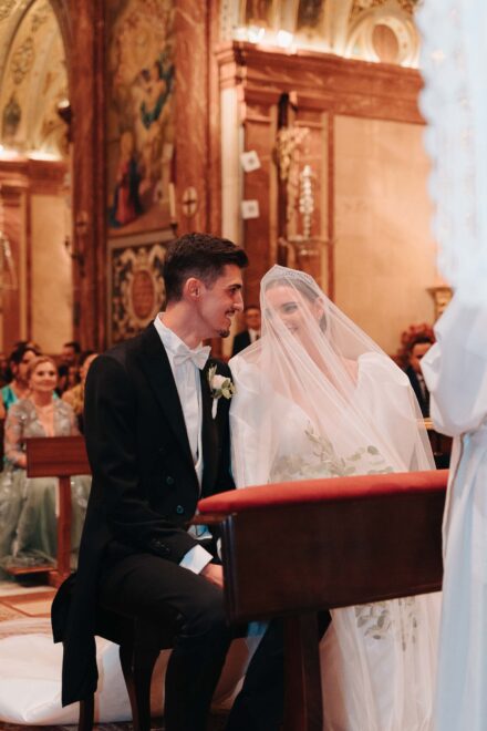 Bride and groom sharing an intimate moment during their wedding ceremony at Basilica de la Macarena in Seville