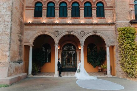 Bride and groom facing each other in front of Castillo de la Monclova during their wedding in Seville