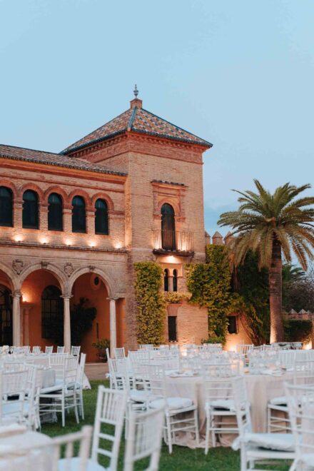 Outdoor wedding reception setup at Castillo de la Monclova in Seville at sunset.
