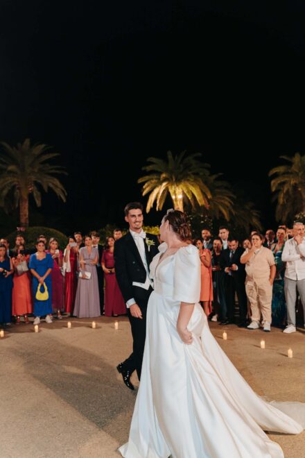 Bride and groom dancing surrounded by guests at night at Castillo de la Monclova in Seville.