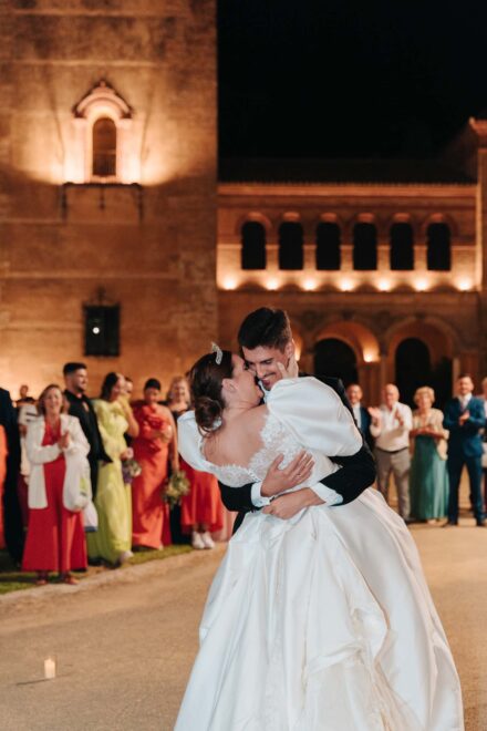 Bride and groom dancing surrounded by guests at night at Castillo de la Monclova in Seville.