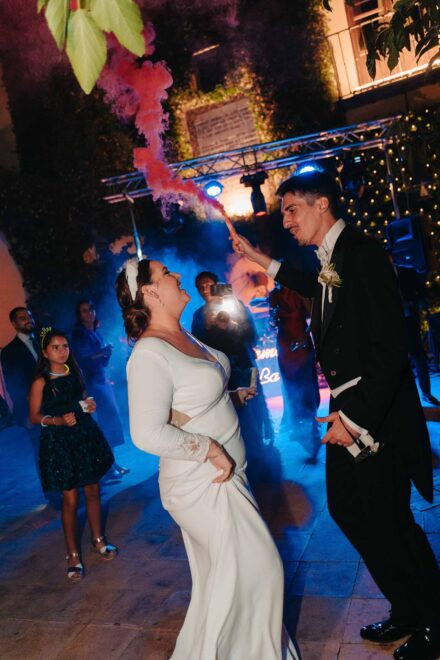 Bride and groom dancing with smoke flare during wedding party at Castillo de la Monclova in Seville