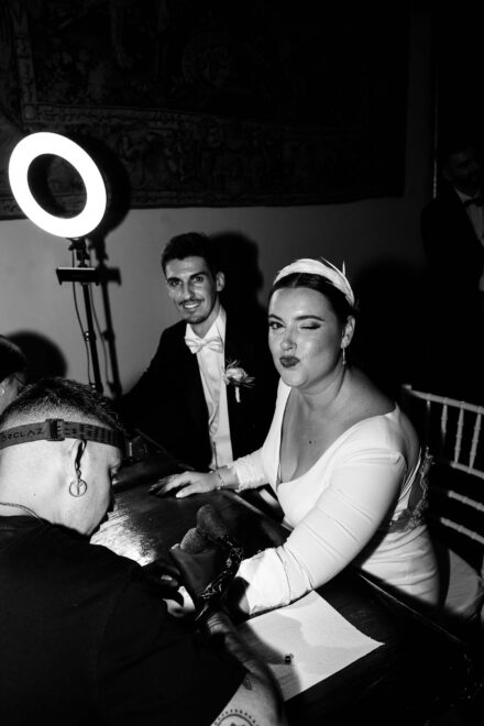 Bride winking while getting a tattoo during wedding celebration in Seville