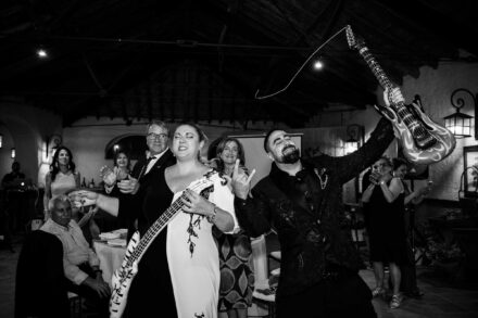 Los novios posan como estrellas del rock con una guitarra cada uno durante la fiesta, en blanco y negro