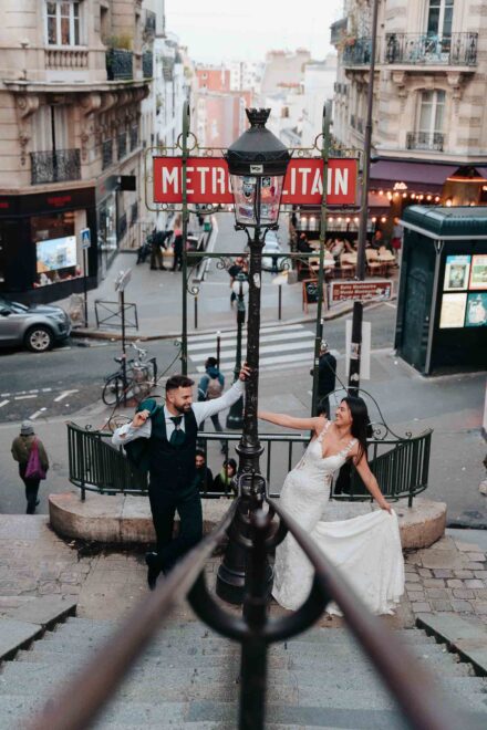 Los novios se agarran a una farola bajo un cartel de «Metropolitain», en lo alto de una escalera de Montmartre