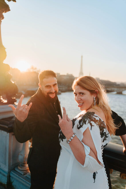 En la postboda en París, los novios sacan la lengua y hacen los cuernos con la mano, con la torre Eiffel a contraluz