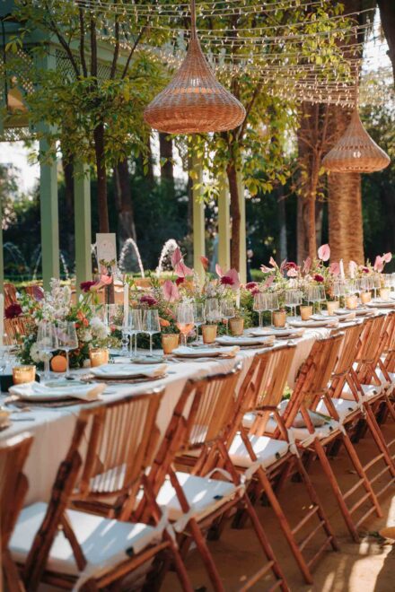 Exotic floral centerpieces and hanging lamps at a vibrant Villa Luisa wedding in Seville